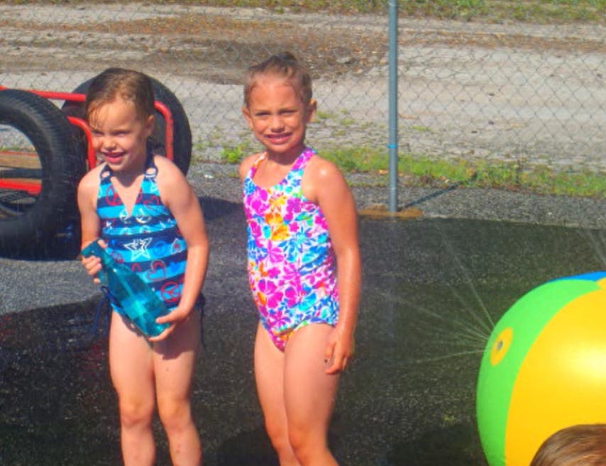 Two children in swimsuits standing in water