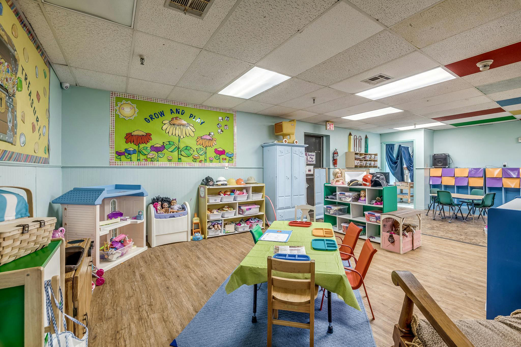 Classroom with tables, chairs, and shelves with toys and supplies