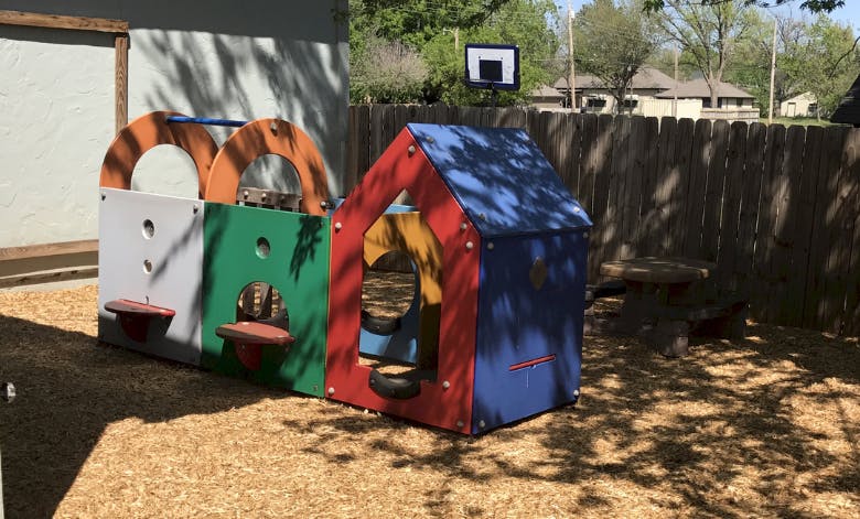 Colorful outdoor play structure with a small house and activity panels