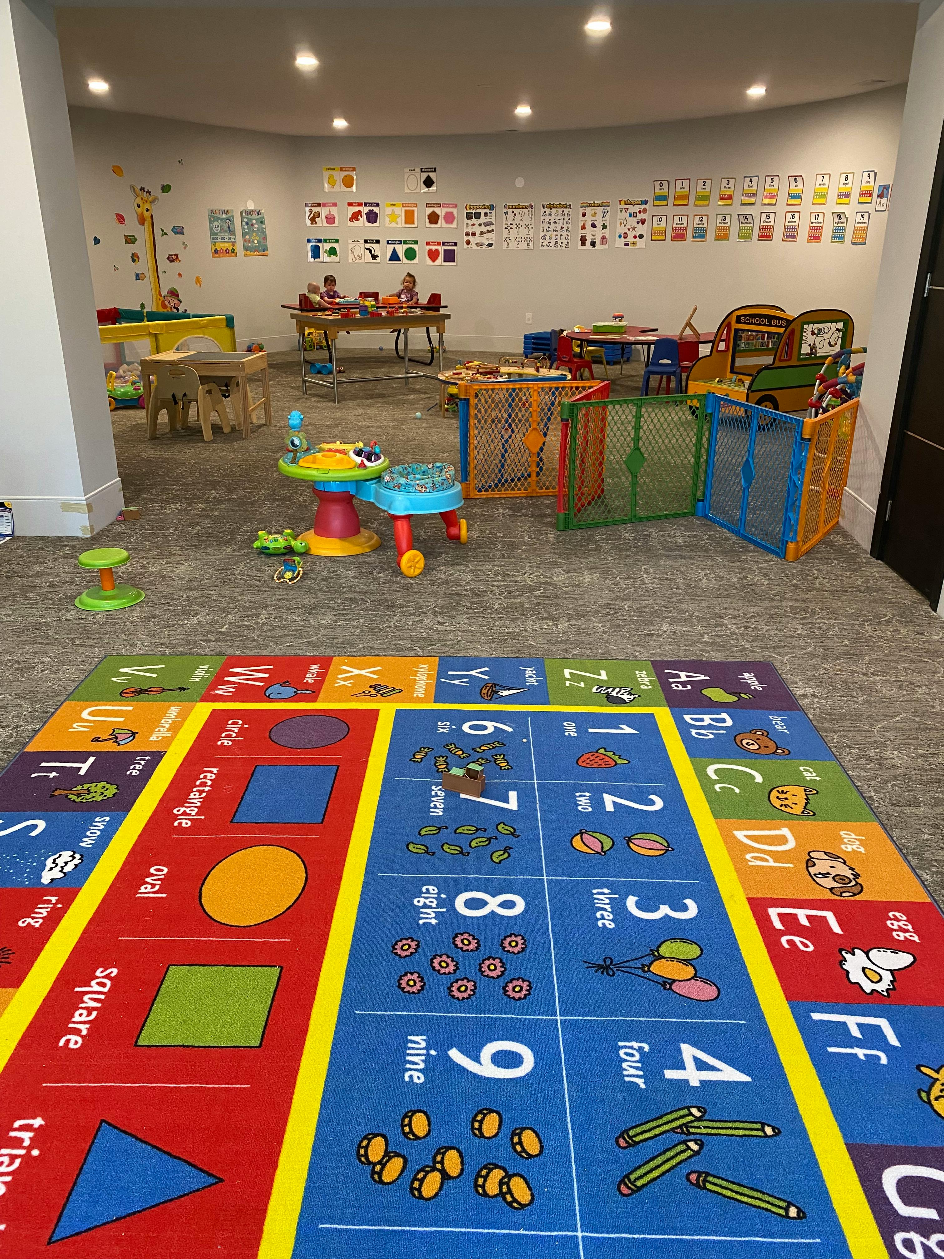 Children's play area with a colorful alphabet and numbers rug