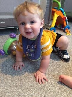 Child crawling on carpet wearing a bib