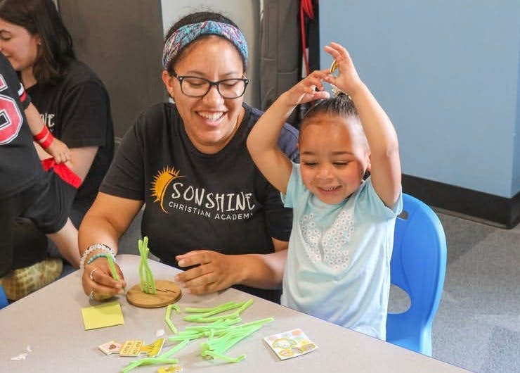 Adult and child playing a table game with green pieces