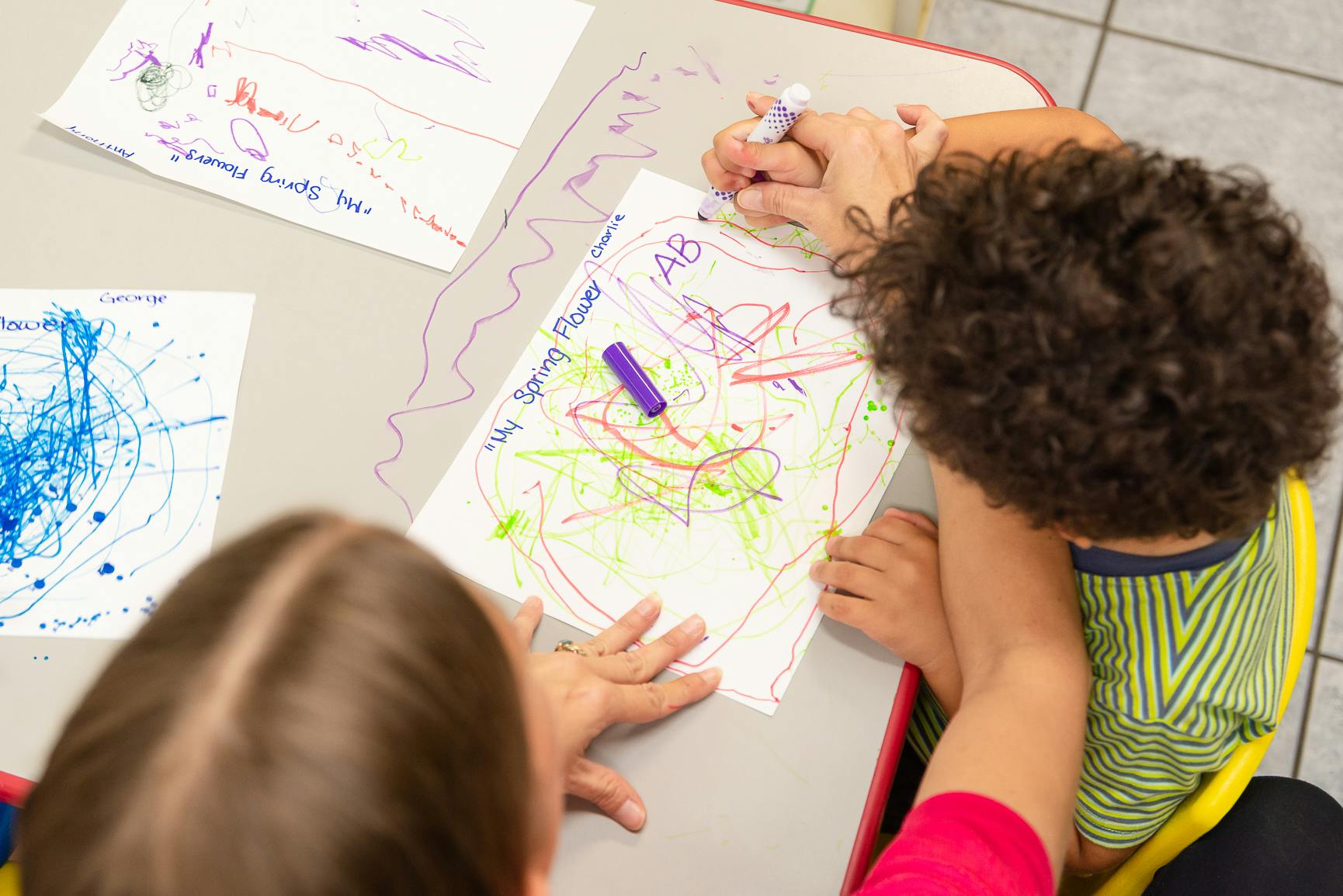 Child drawing on paper with markers