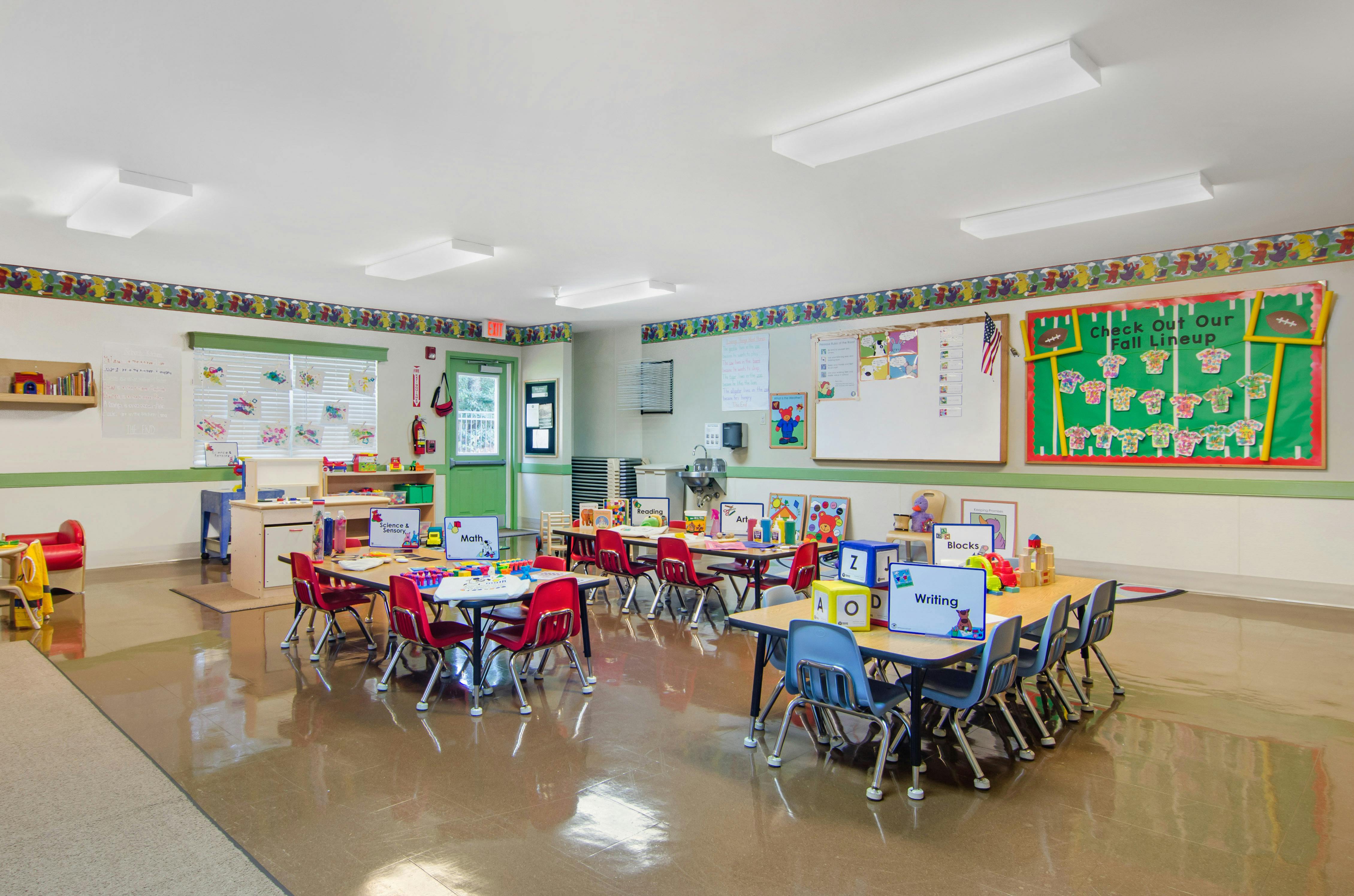 Classroom with tables, chairs, and various learning stations for children