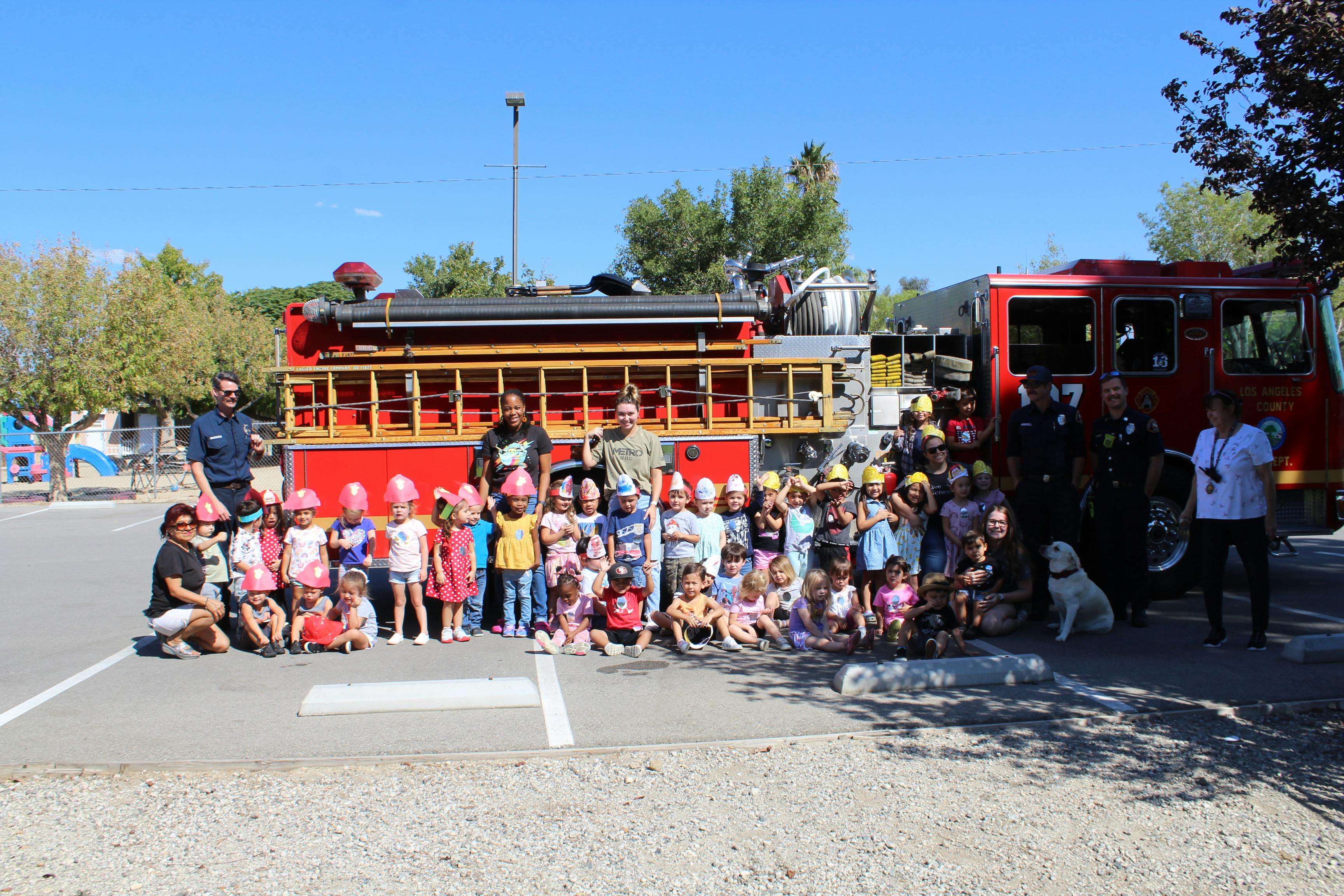 Group of adults and children posing in front of a fire truck