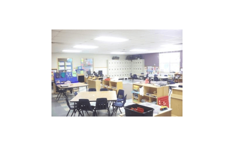 Classroom with tables, chairs, lockers, and various learning materials