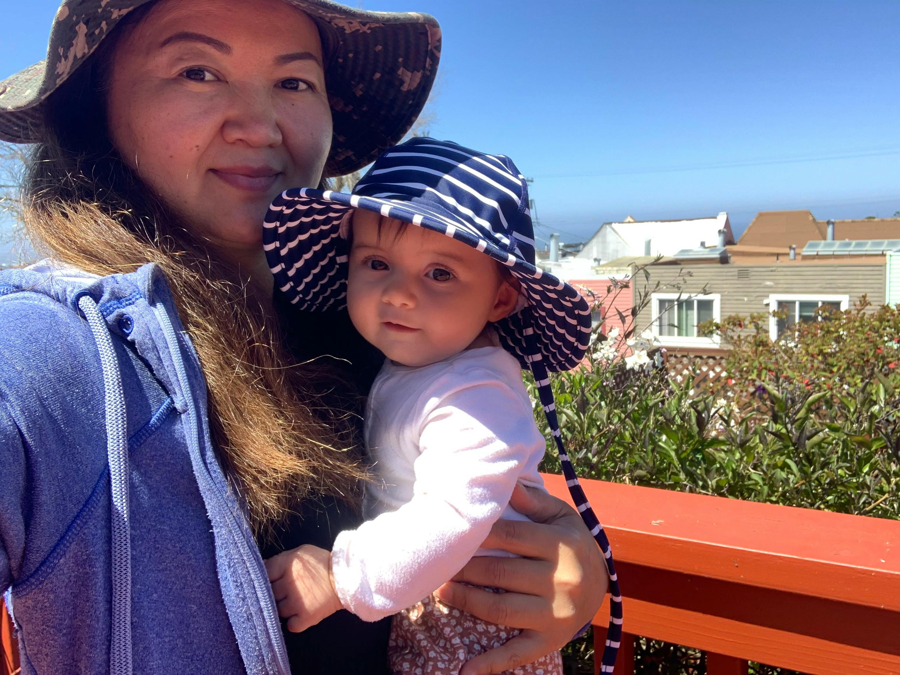 Person holding a child wearing a striped hat