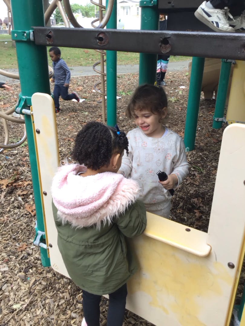 Two children interacting on a playground structure