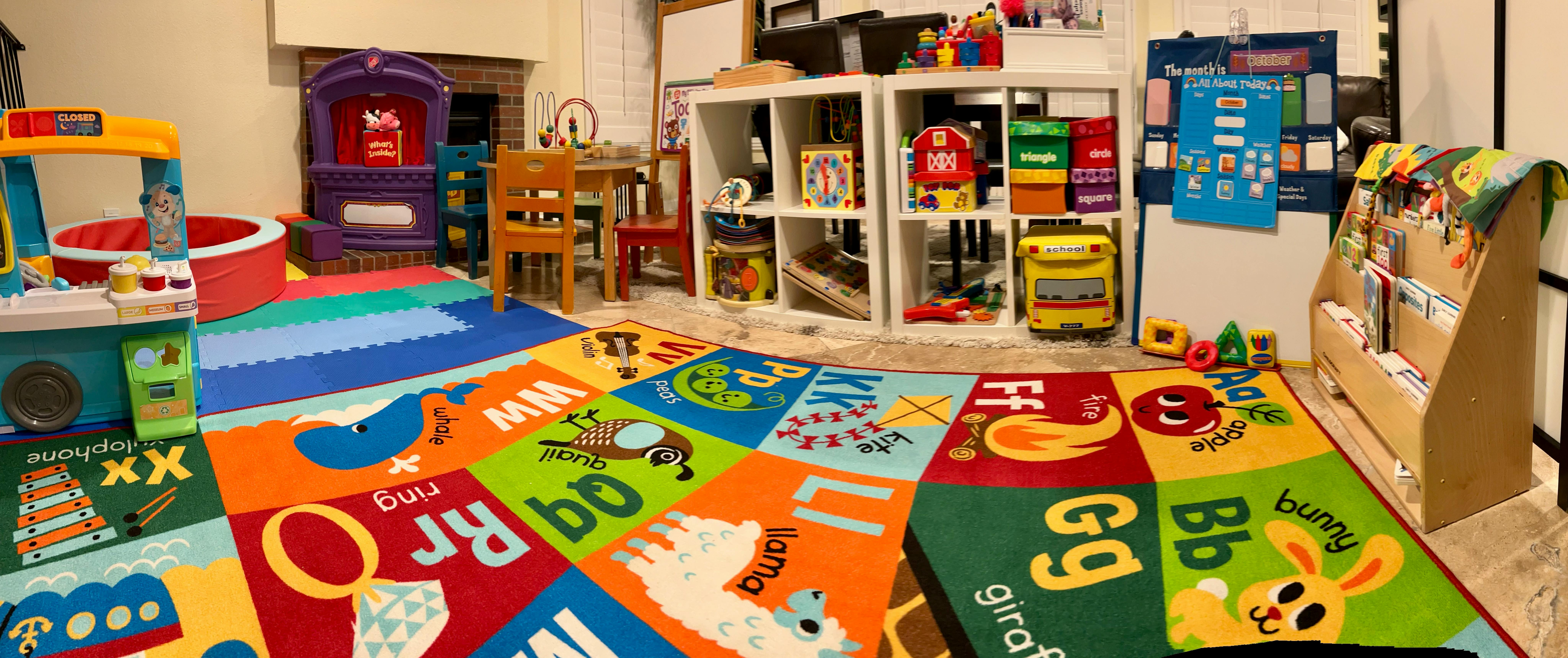 Playroom with colorful alphabet rug and various toys