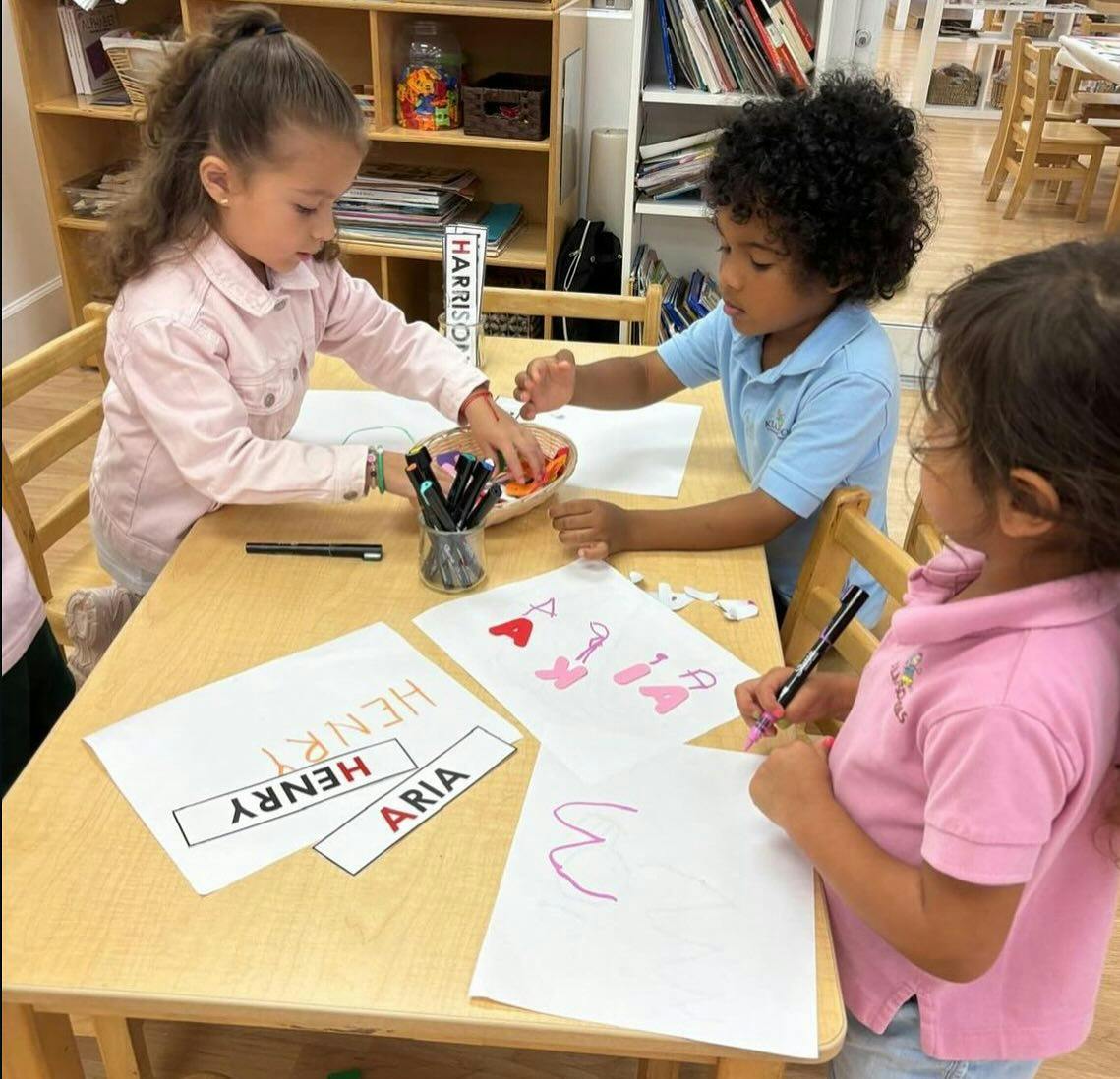 Three children drawing and coloring at a table