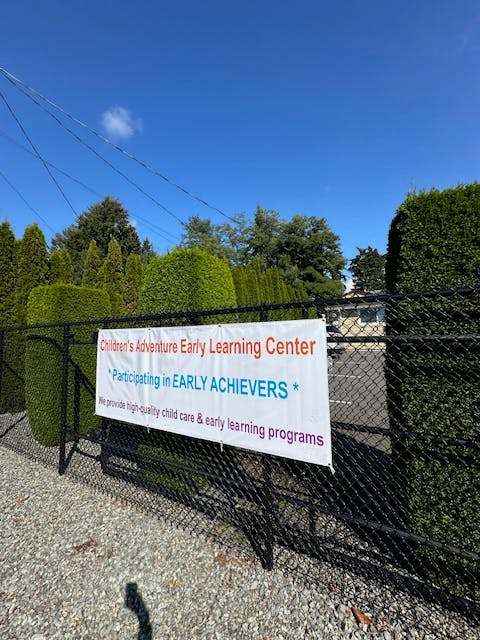Sign for Children's Adventure Early Learning Center on a fence