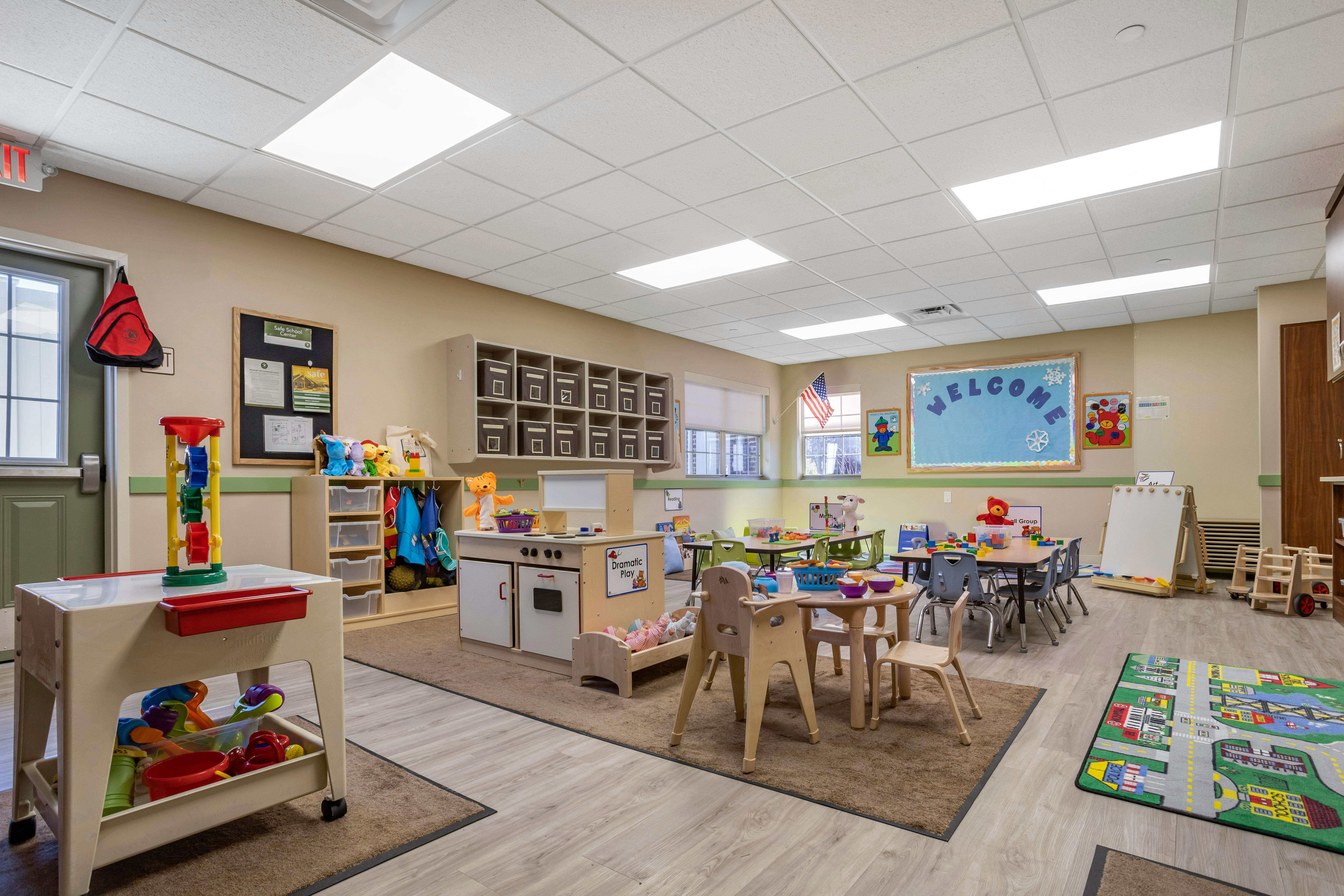 Classroom filled with child-sized tables, chairs, and play areas