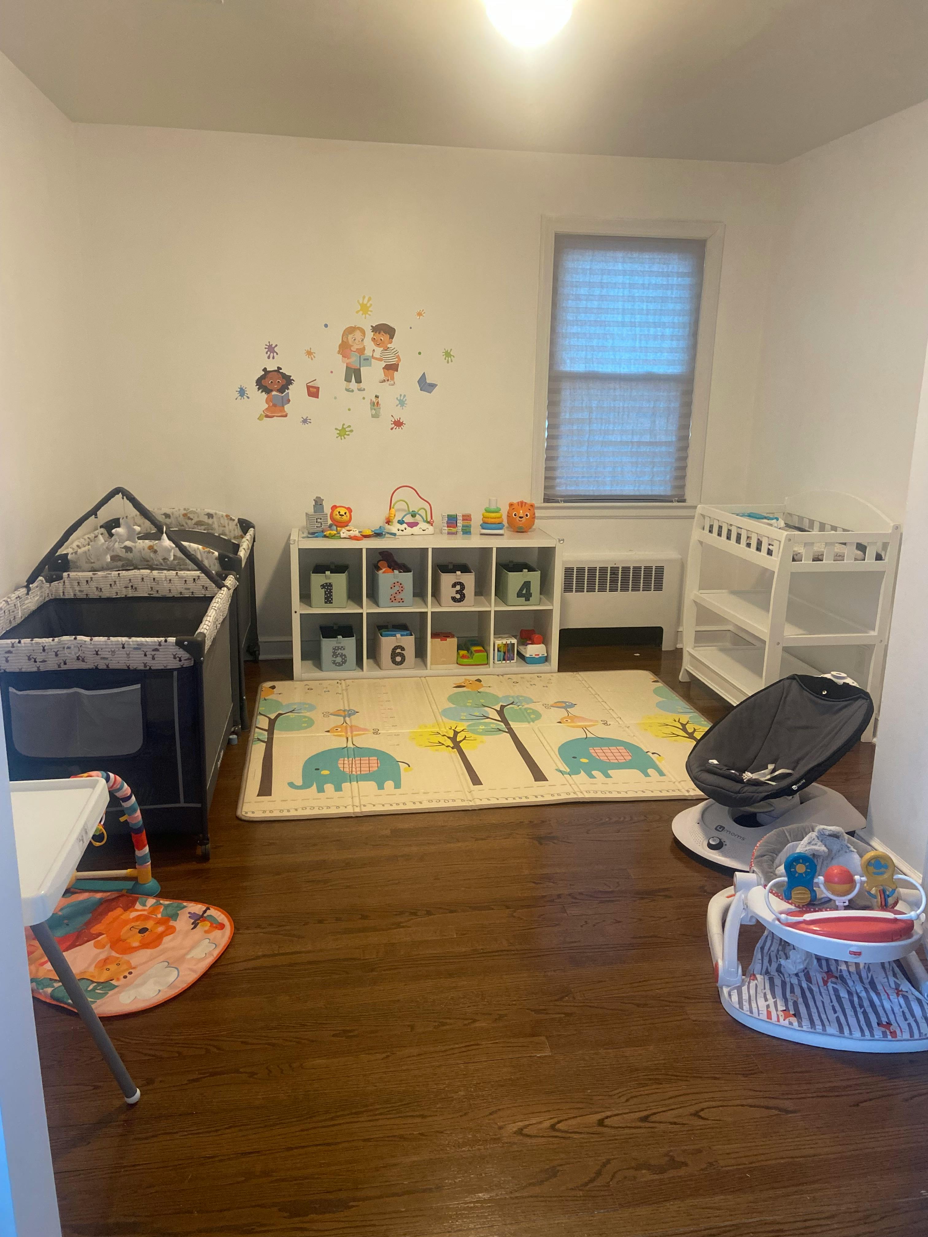 Nursery room with a crib, changing table, play mat, and toy storage