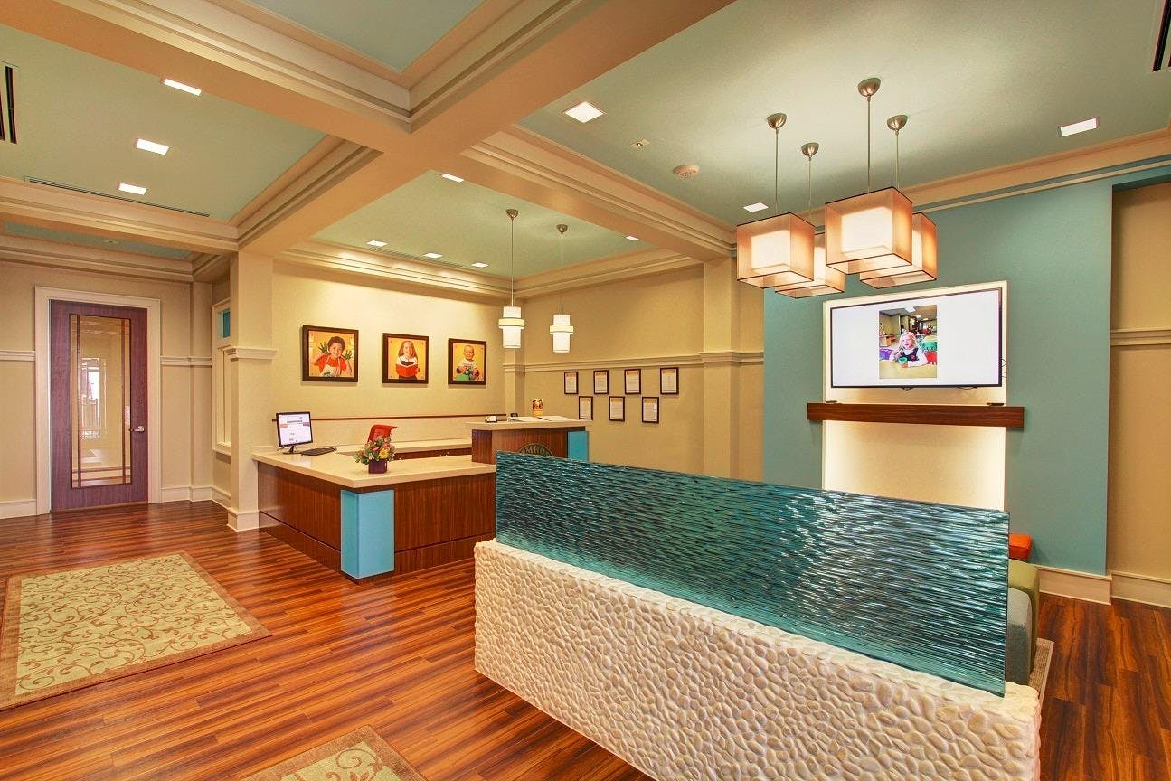 Reception area with a front desk, a computer, and a television screen displaying an image