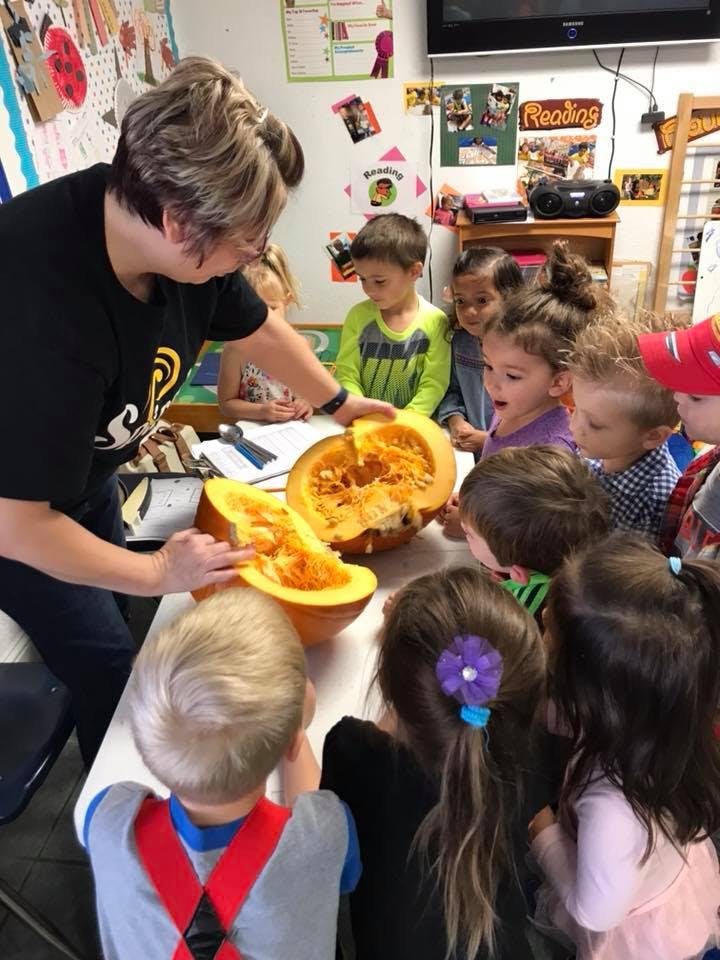 Person showing children the inside of a pumpkin