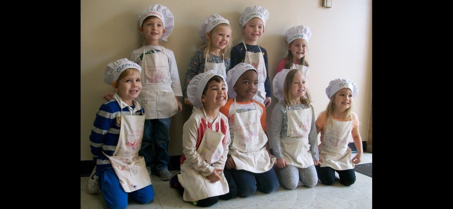 Group of children wearing chef hats and aprons