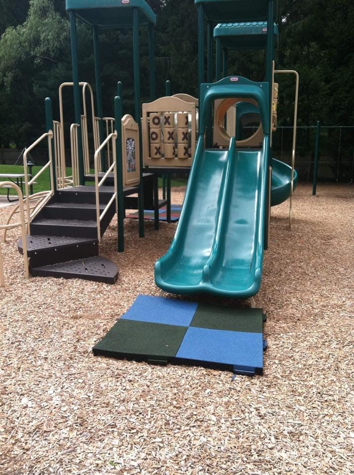 Playground structure with slides and stairs on wood chips