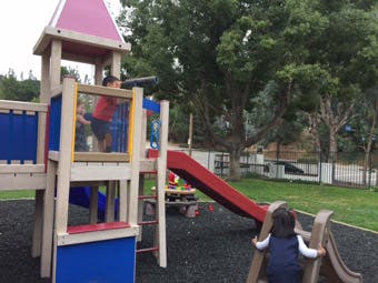 Child on a playground structure with a slide