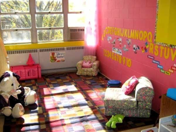 Classroom with alphabet on wall, small chairs, and stuffed animals