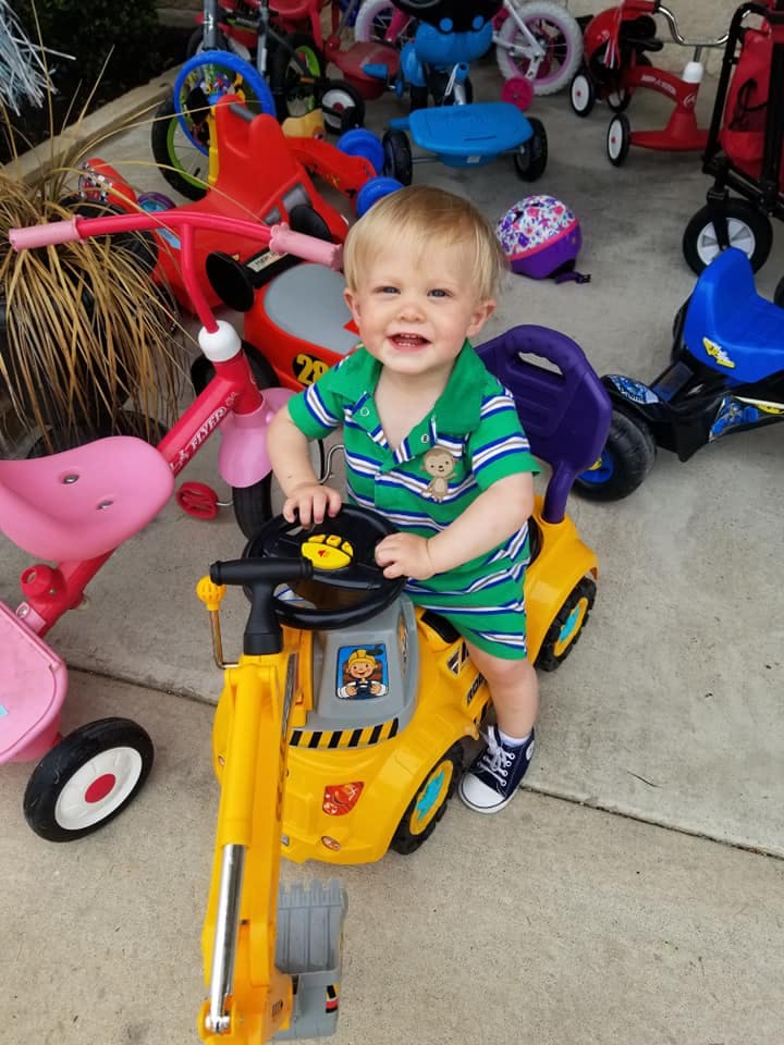 Child on a yellow toy construction vehicle