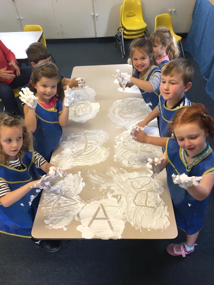 Children playing with shaving cream on a table