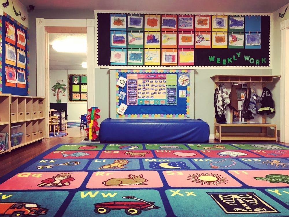 Classroom with colorful alphabet rug and bulletin boards