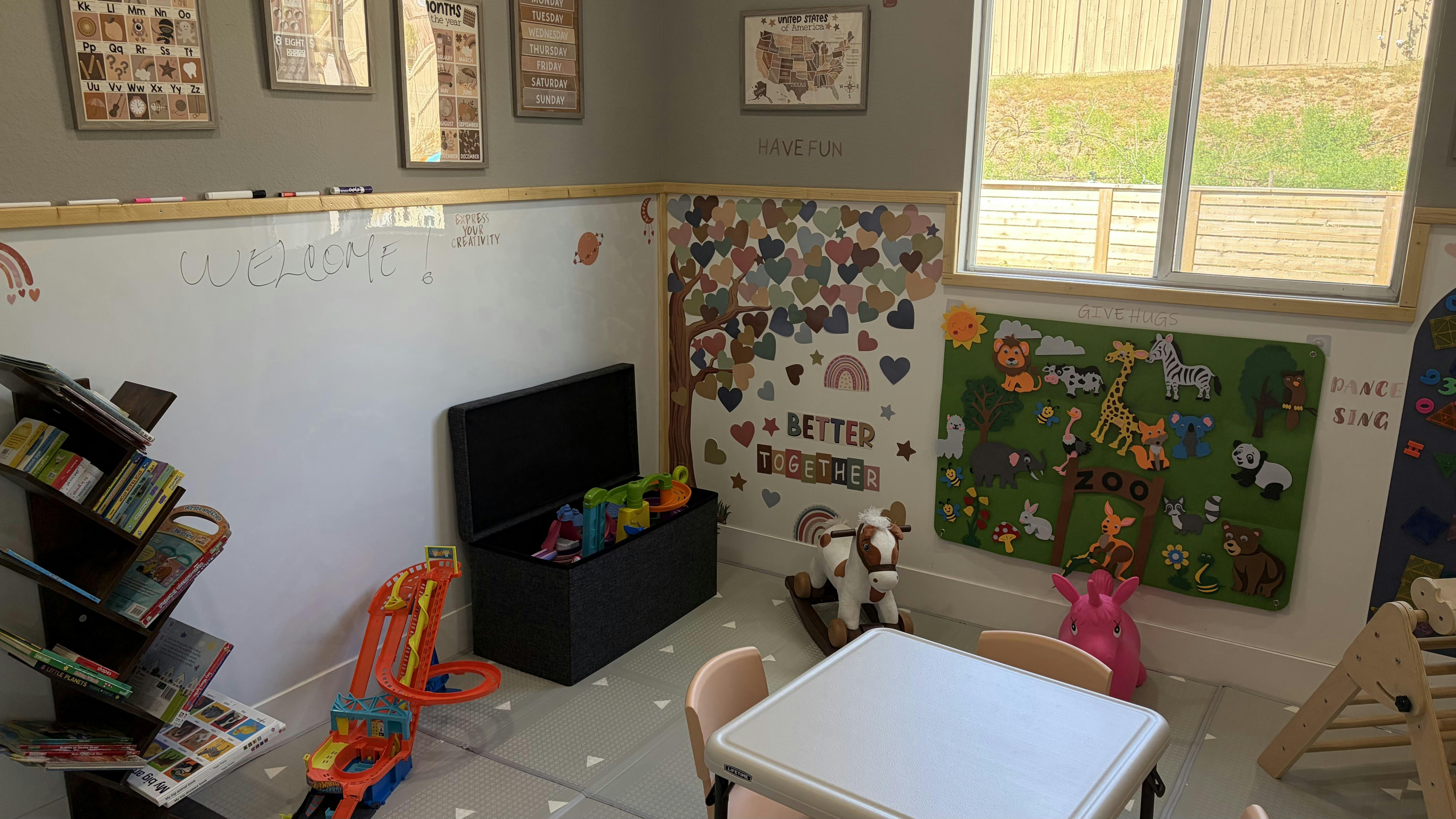 Children's playroom with a whiteboard, animal-themed decor, and toys