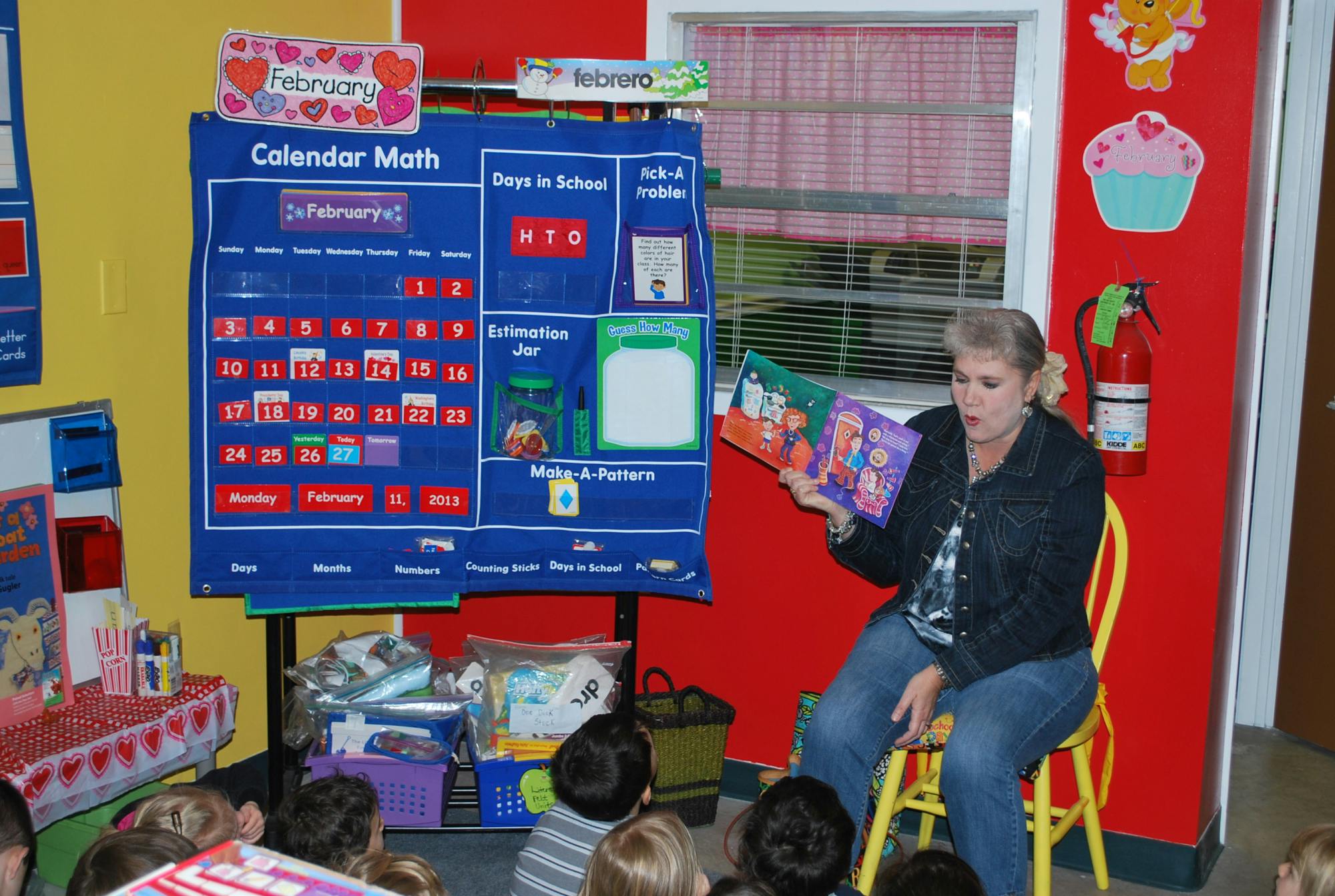 Person reading a book to children in a classroom