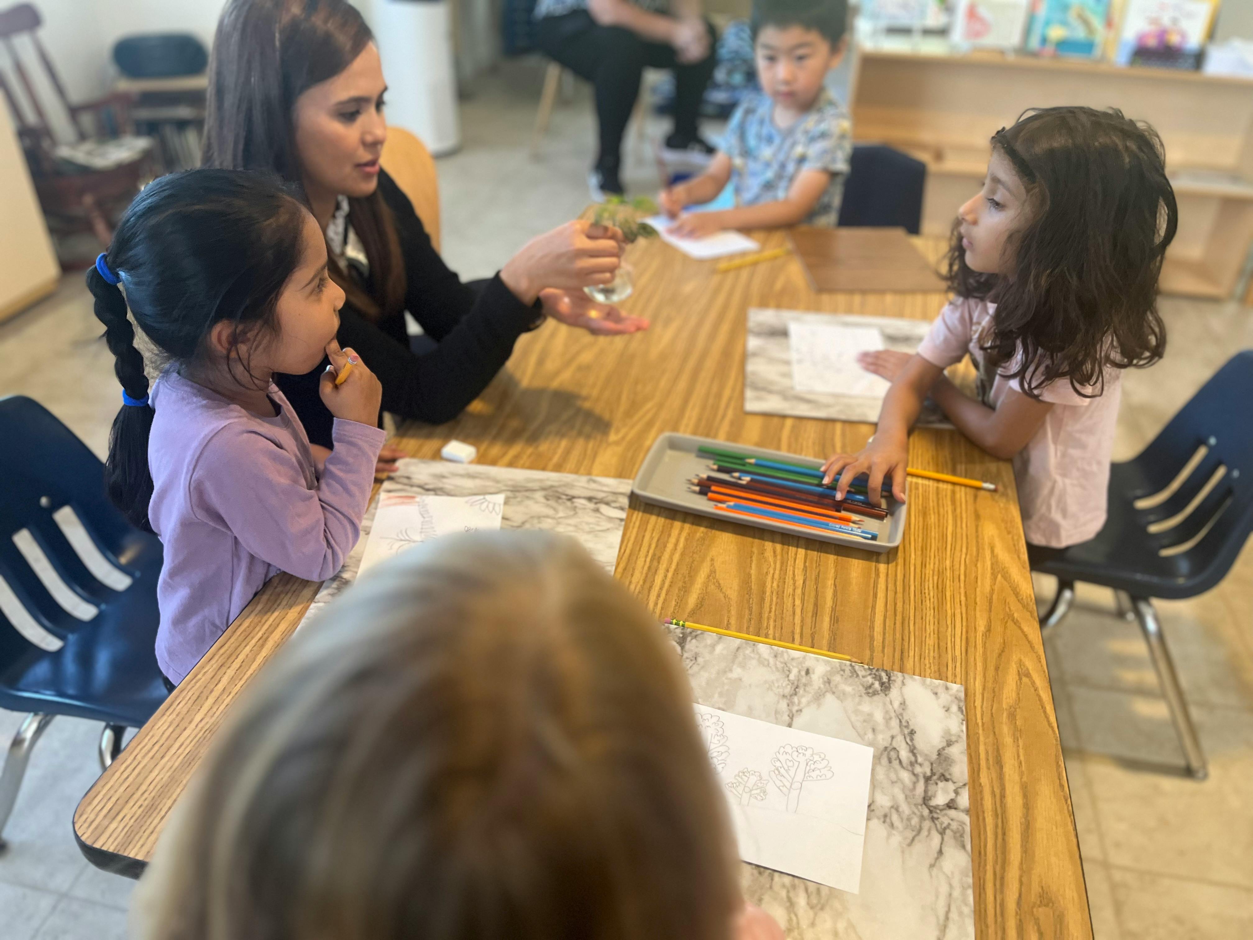 Adult and children at a table with art supplies