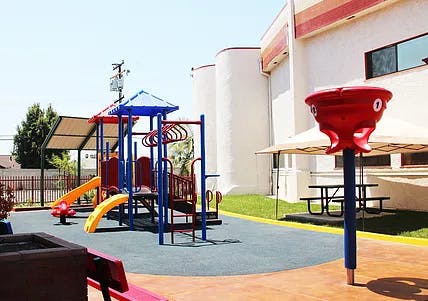 Playground with slides and climbing structures next to a building