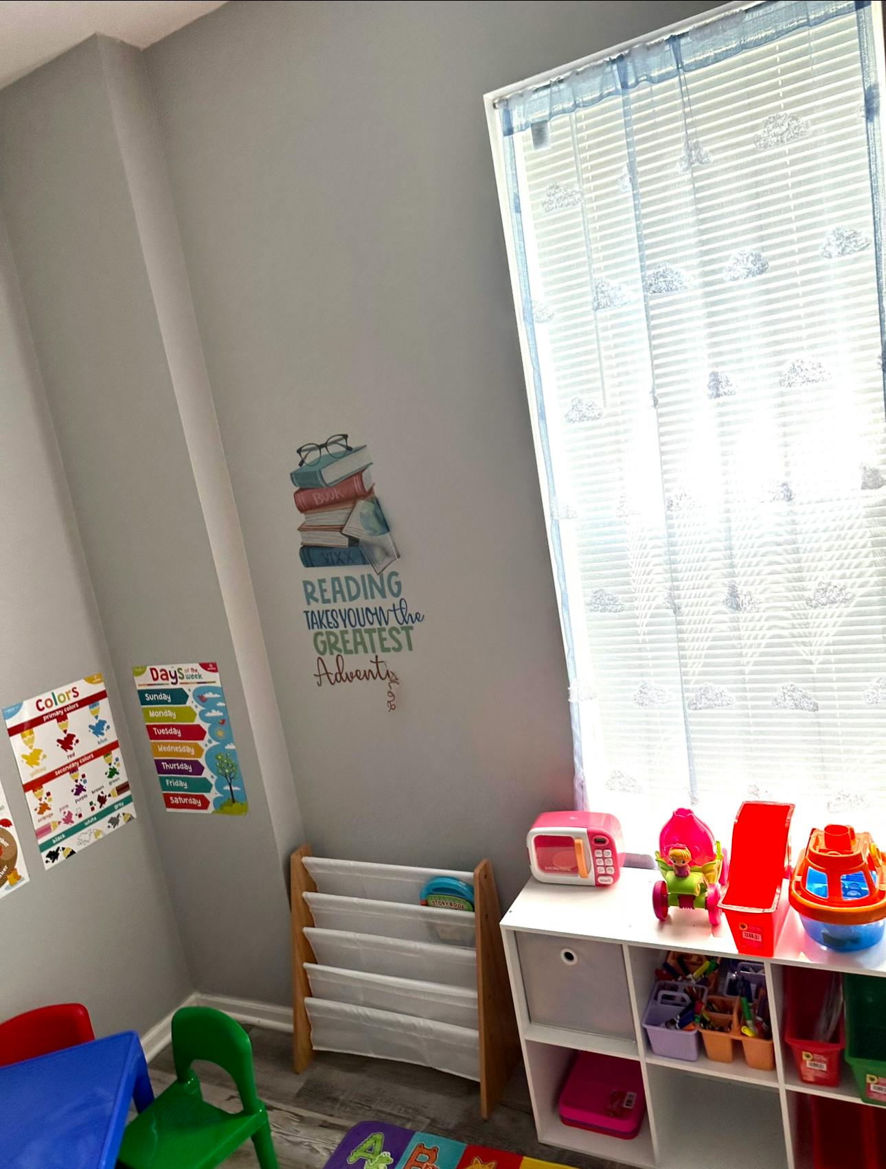 Children's play area with toy storage, small table, and book display