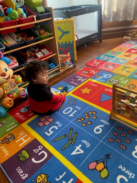 Child playing on an educational alphabet and number floor mat