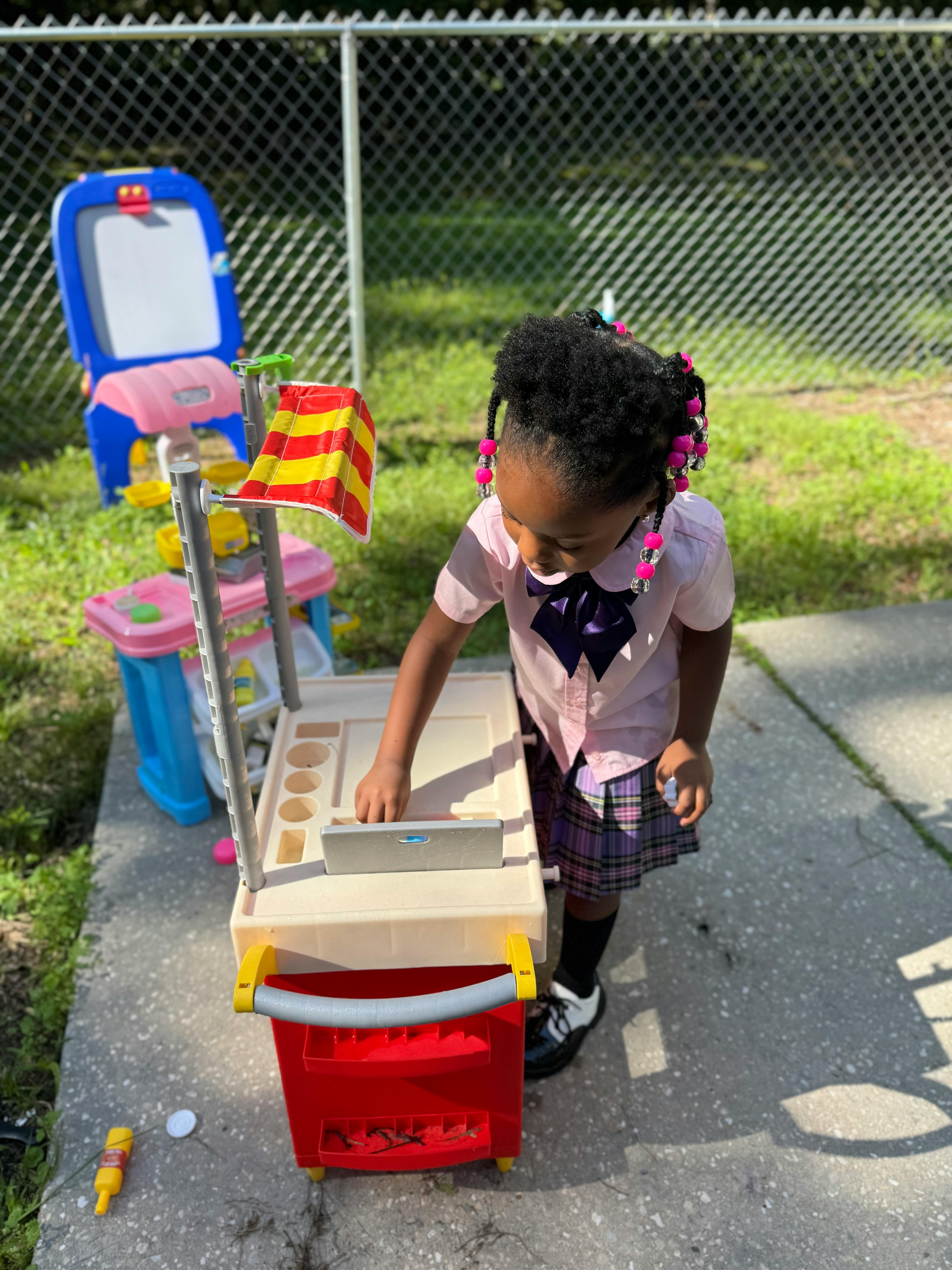 Child playing with a toy cart outdoors