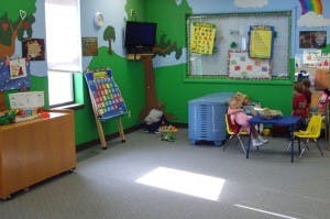 Child sitting at a table in a classroom