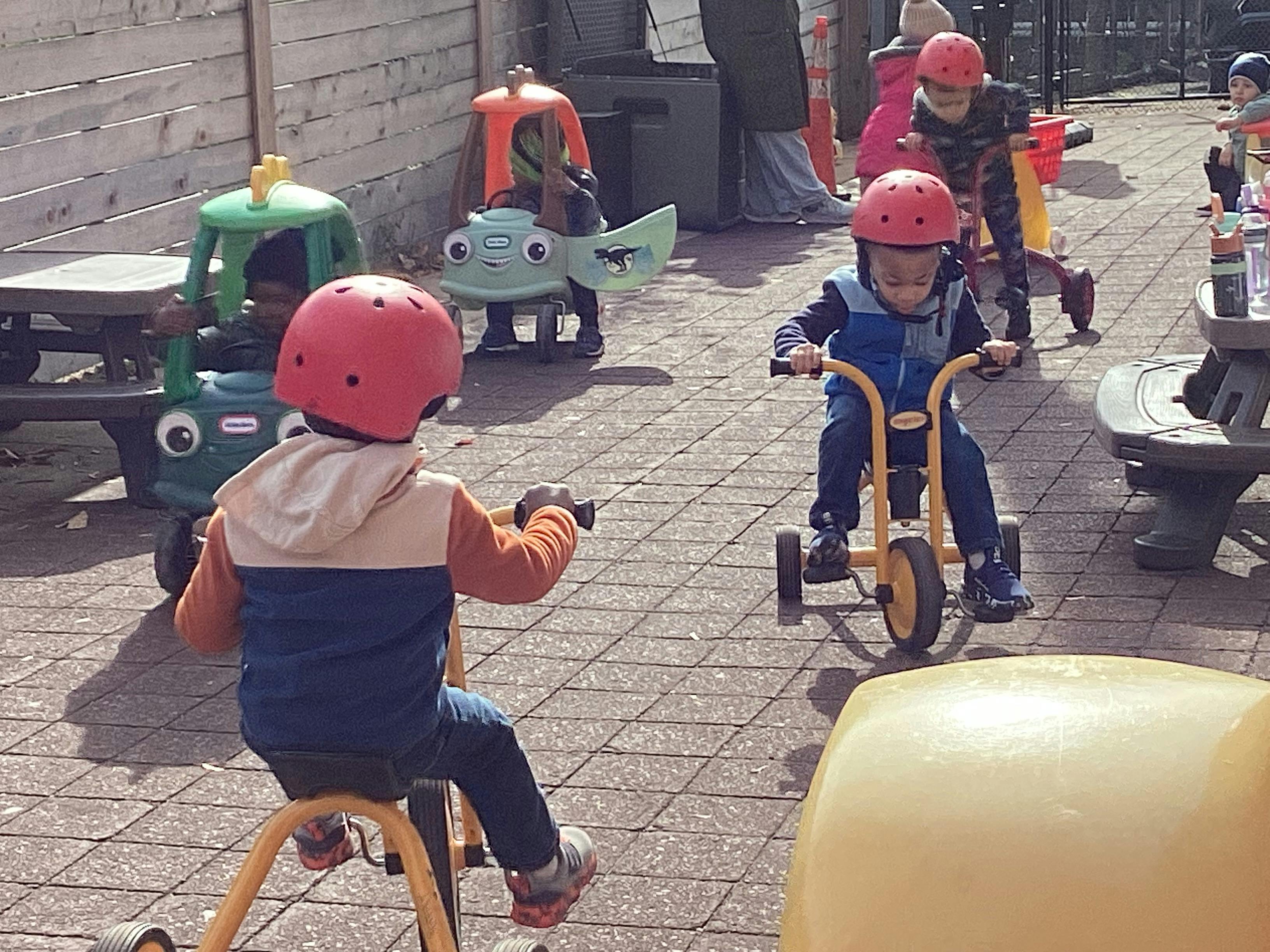 Children riding tricycles outdoors