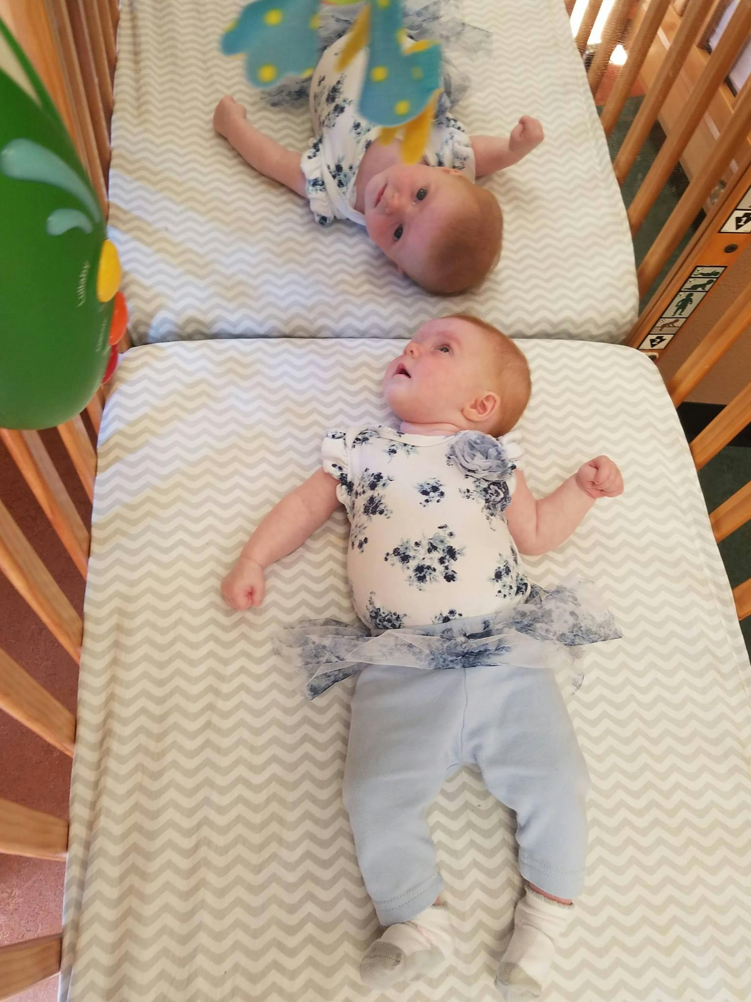Two babies lying in a crib
