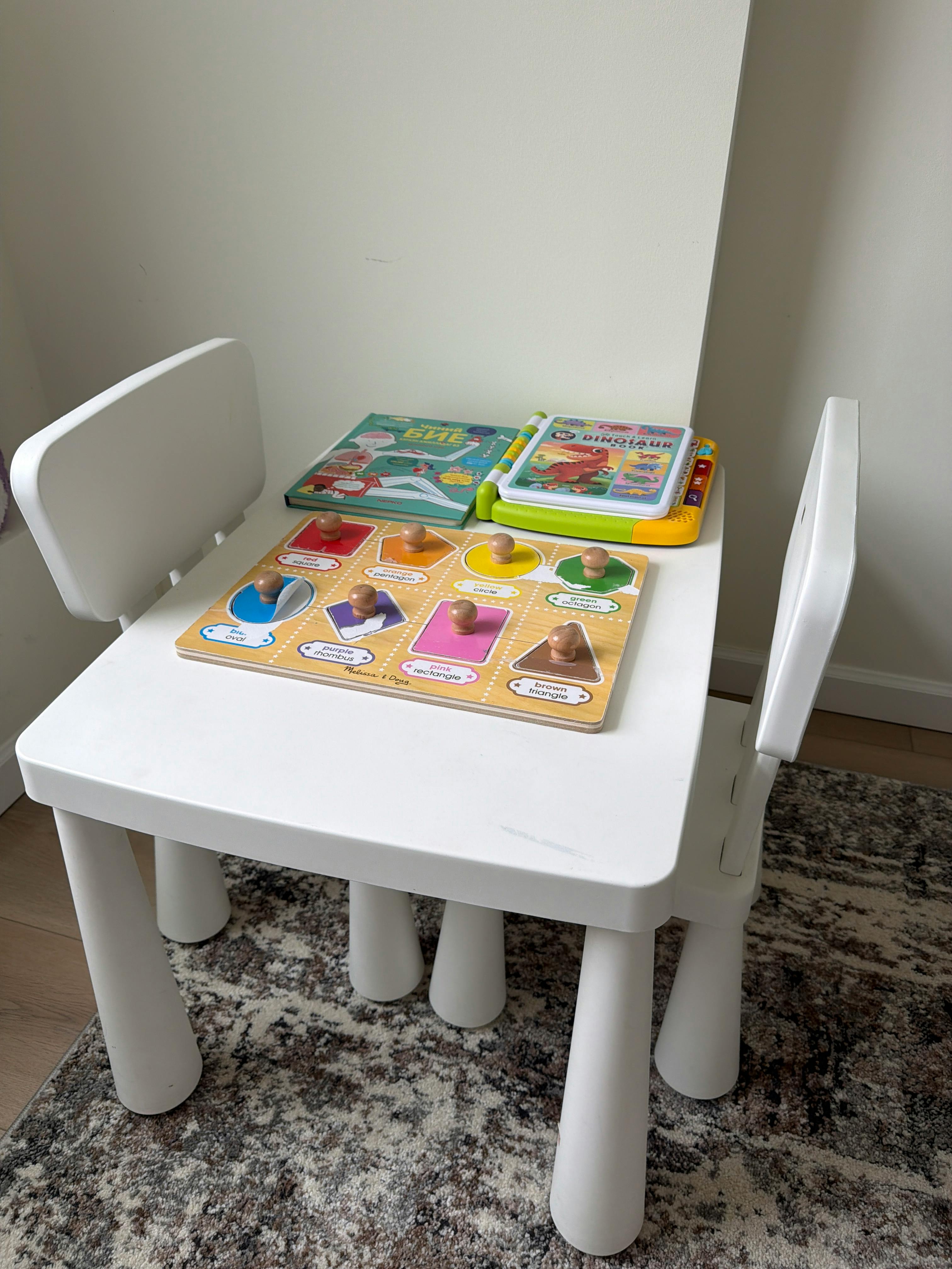children's activity table with a shape puzzle and two toy books