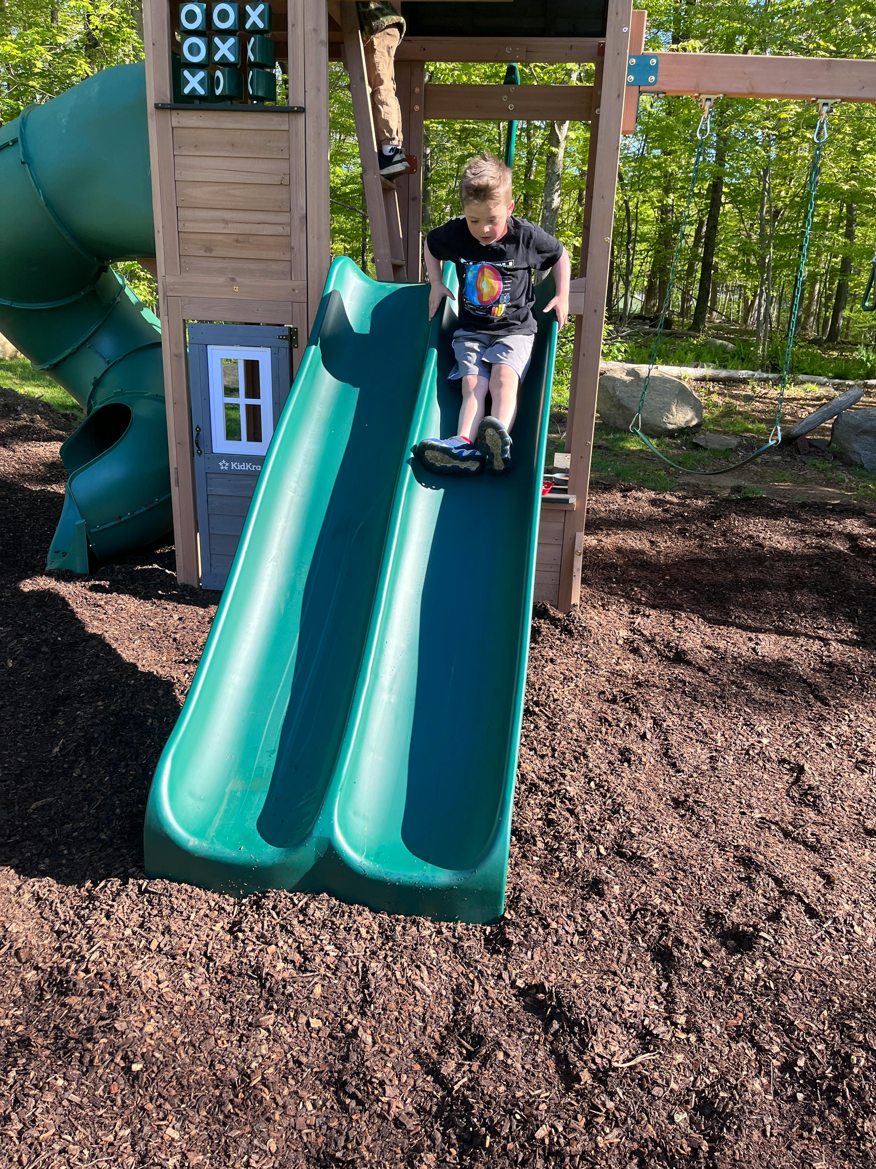 Child on a green slide on a playground