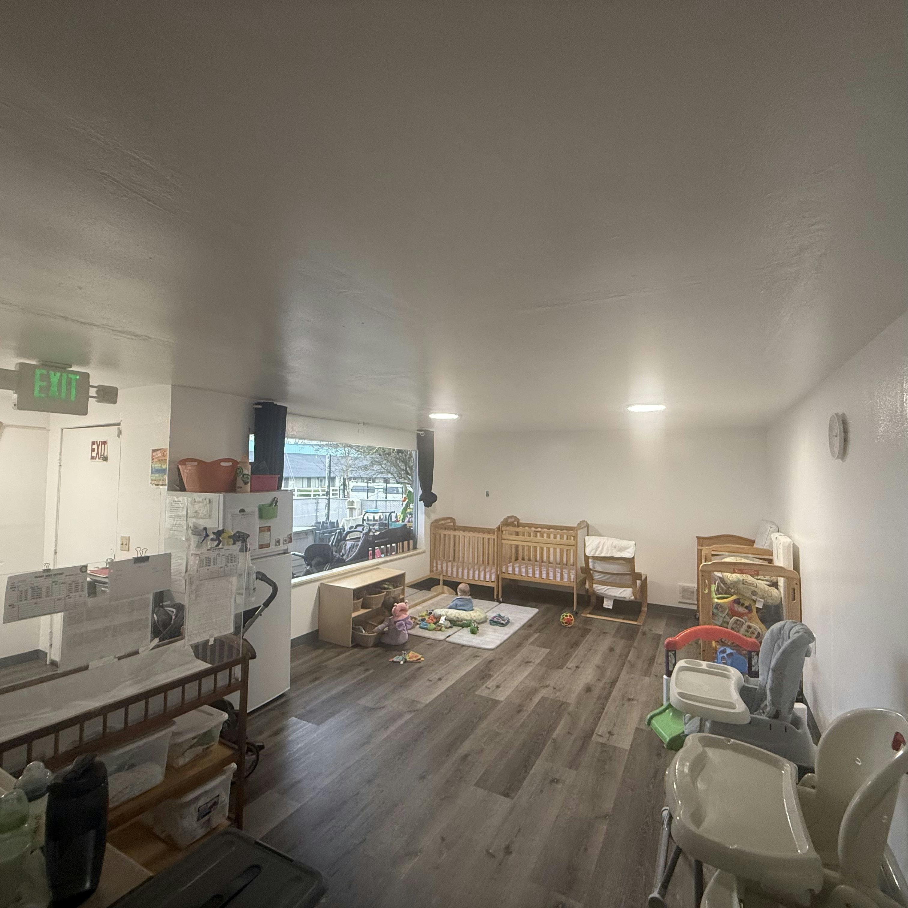 Playroom with cribs, playmats, and high chairs