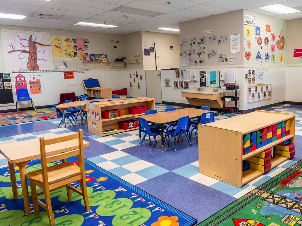 Colorful empty classroom with small tables and chairs
