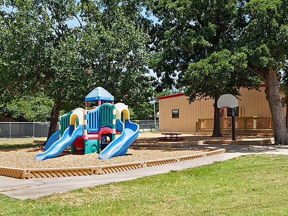 Playground with slides and a tan building in the background