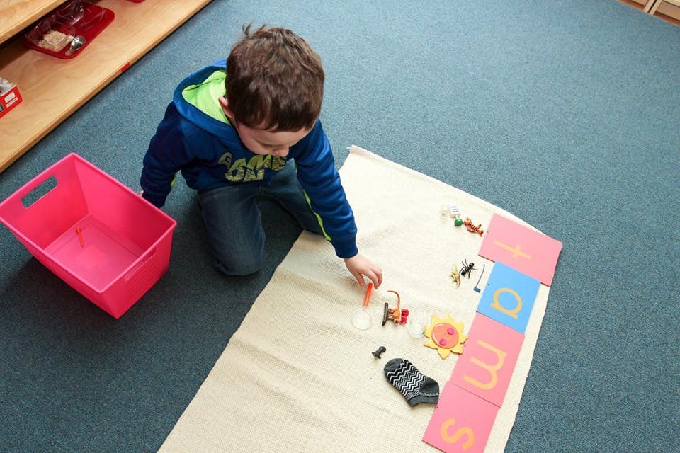 Child playing with small objects on a mat