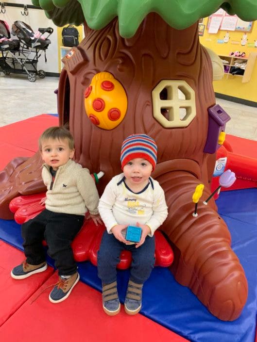 Two children sitting on a play structure