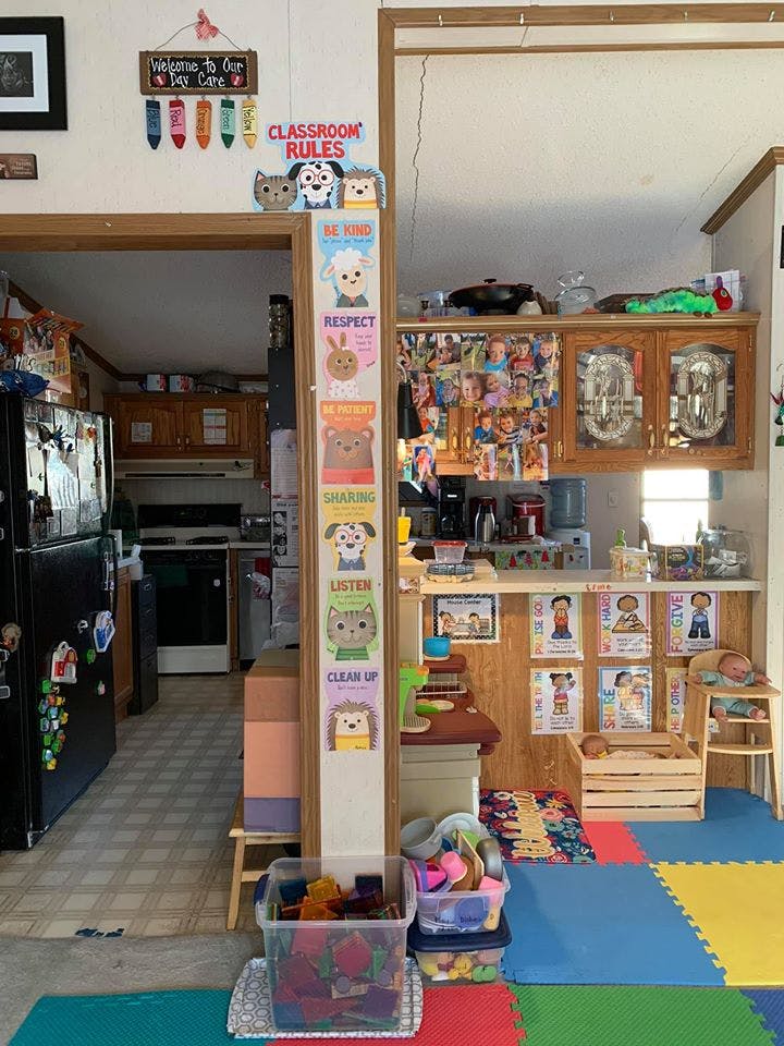Classroom rules sign and posters with cartoon animals, kitchen in background