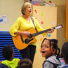 Person playing guitar for children