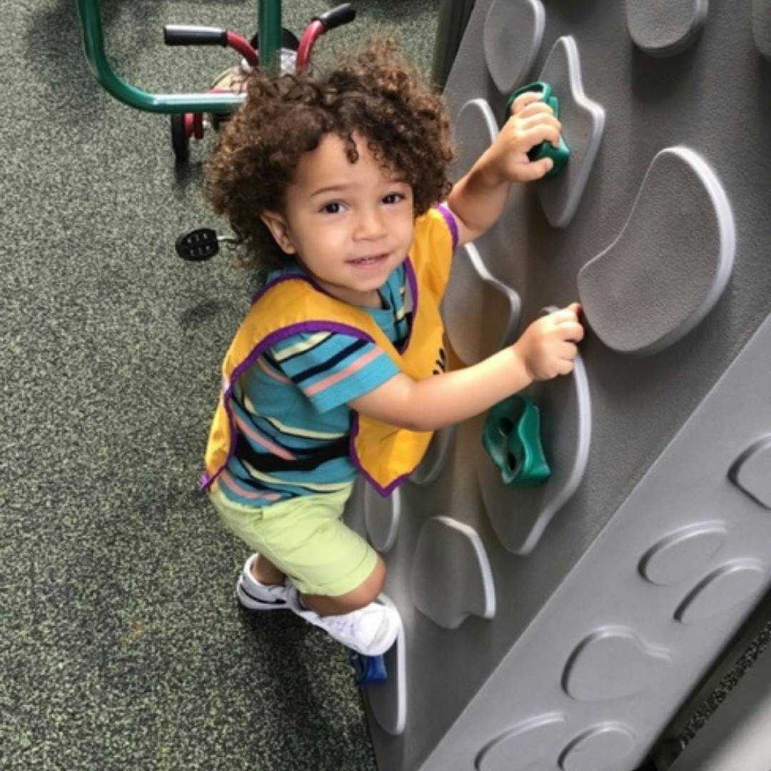 Child climbing a rock wall on a playground