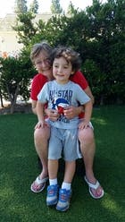 Person sitting with a child on their lap outdoors