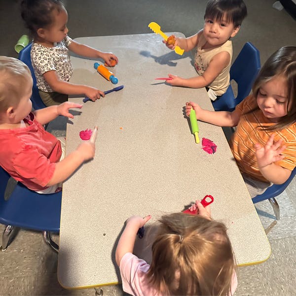 Children playing with modeling clay at a table