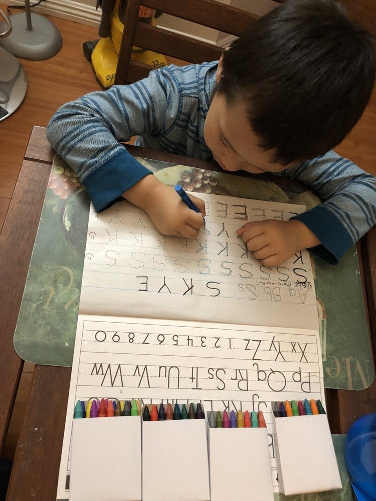 Child writing letters on a worksheet