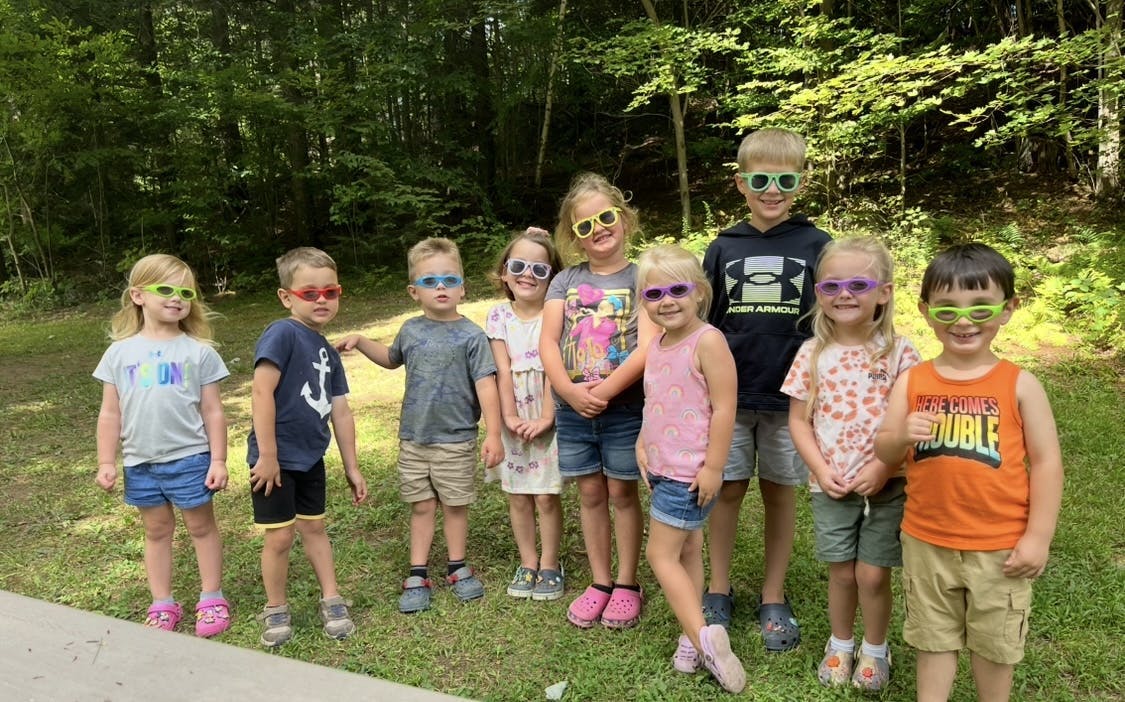 Group of children wearing sunglasses standing outdoors